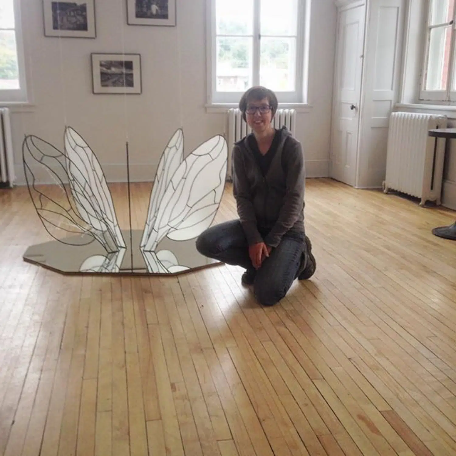 Installation d'ailes en vitrail déposées sur un miroir avec l'artiste Annabelle Nicole.